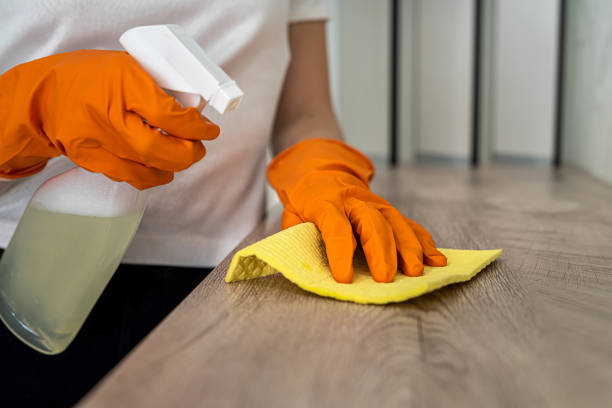 istock beautiful female hands in orange mittens wipe the kitchen surface from dust 1358737570