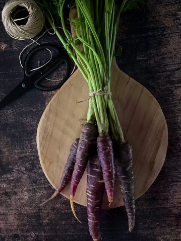 Still life background with purple carrots