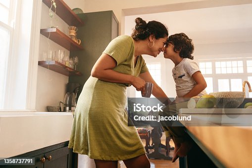 istock Affectionate mother touching noses with her young son 1358737791