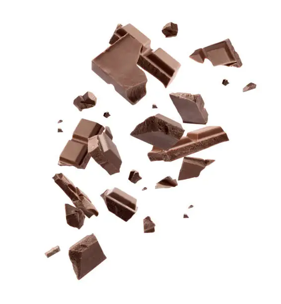 Photo of Milk chocolate pieces falling on white background