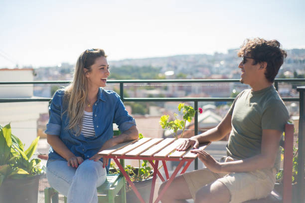 istock Male and female friends sitting at table talking 1358740176