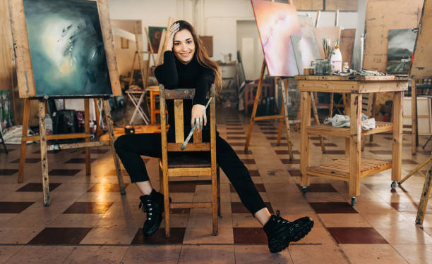 istock Cheerful female artist smiling at the camera in her workshop 1358740260