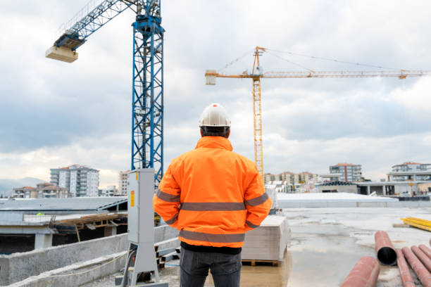 bauingenieur untersucht arbeiten auf der baustelle - leuchtbekleidung stock-fotos und bilder