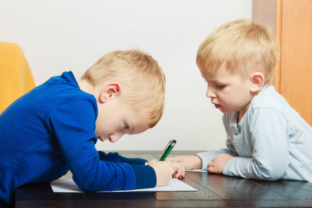 istock Kids playing together, drawing pictures on paper 1358741636