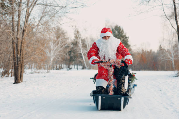 istock Santa claus riding snowmobile in the winter forest 1358741684