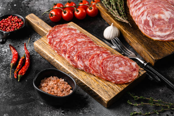 istock Cold smoked meat slices prosciutto, on black dark stone table background 1358742129