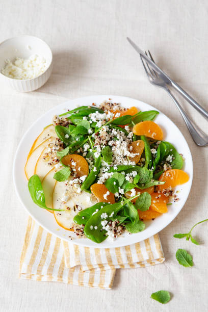 spinach and quinoa salad with pears, oranges and ricotta. healthy meal prep. plant-based dishes. green living. vegan recipe. food styling. vegetarian cuisine. healthy eating. weight loss food. - food styling imagens e fotografias de stock
