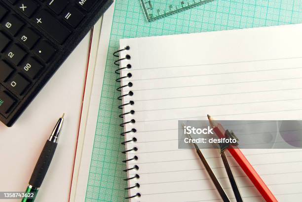 Geometry Tools An Open Compass Placed Over A Page Of A Spiral Notepad And Graph Paper With Calculator And Set Square In The Hindsight Stock Photo - Download Image Now