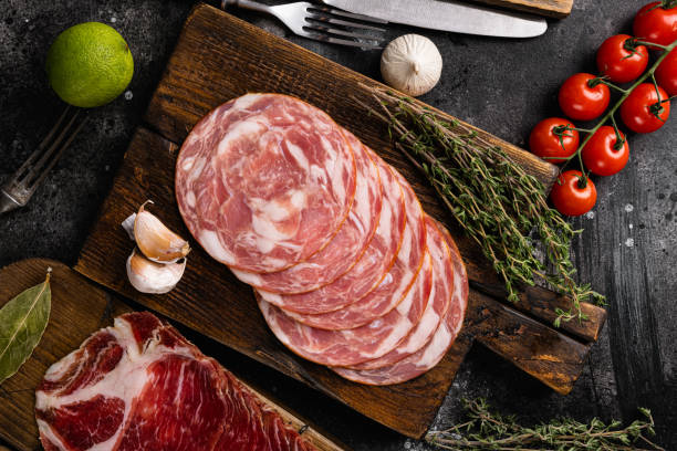istock Sliced sausages , on black dark stone table background, top view flat lay 1358743946