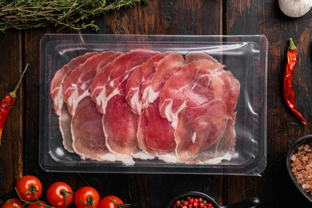 istock Prosciutto crudo slices package, on old dark  wooden table background, top view flat lay 1358744024