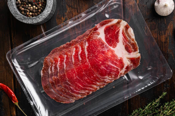 istock Sliced Ham Salami coppa plastic pack, on old dark  wooden table background, top view flat lay 1358744039