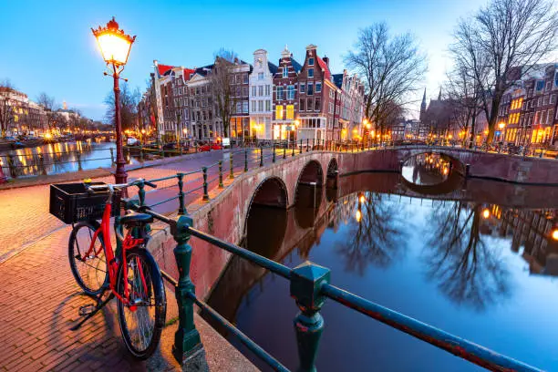 Amsterdam canal Keizersgracht with typical dutch houses and bridge during morning blue hour, Holland, Netherlands