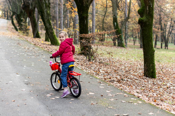 istock Child riding a bike in public park 1358749725