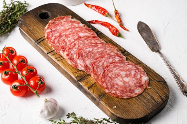 istock Thinly Sliced Milano salami, on white stone table background 1358750936