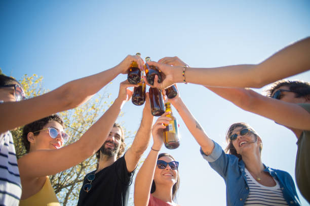 istock Happy friends clinking beer bottles celebrating weekend 1358750978