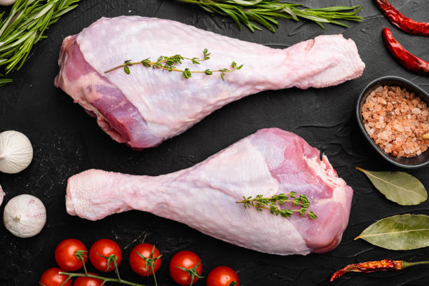 istock Raw turkey thigh with spices, on black dark stone table background, top view flat lay 1358751038