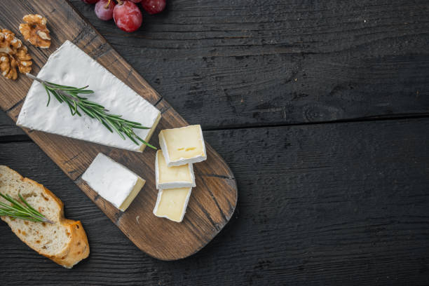 Variety of French and Spanish cheeses on black wooden background