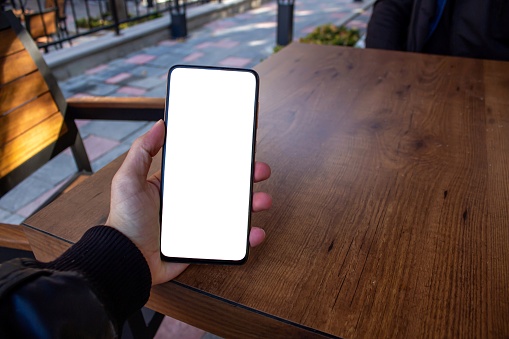 Mockup image of a man hand holding mobile phone with blank white desktop screen. Man hand holding smartphone.