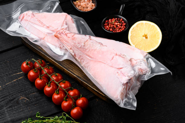 istock Ocean Perch fish meat frozen pack , with herbs, on black wooden table background 1358752398