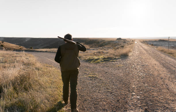 istock Hunter man is walking with the shotgun on his shoulder 1358752608