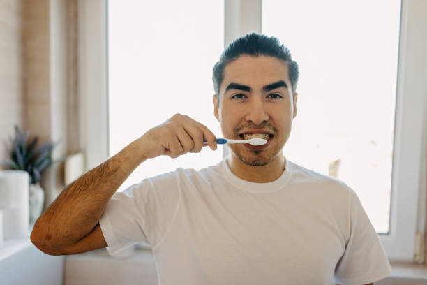 istock Young latin man brushing his teeth 1358755642