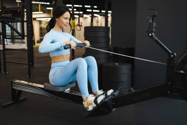 istock Woman doing exercise on rowing machine in gym 1358755749