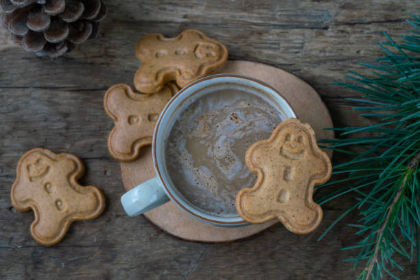 istock coffee and gingerbread noel biscuits on wooden table with pine tree branches for christmas 1358757350
