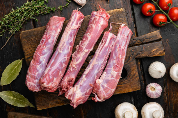 Raw uncooked chicken gizzards, on old dark  wooden table background, top view flat lay