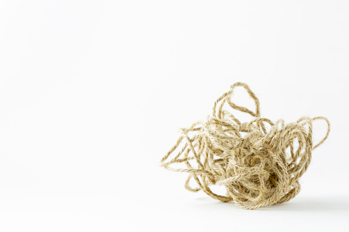 Tangled jute rope on white paper background, complicated or complex issue, mind and mental problem (psychotherapy)