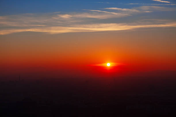 Sunset over the city and mountains . Spectacular orange twilight . Silhouette of the mountains on the horizon