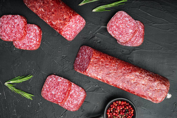 istock Salami with herbs and spices, on black dark stone table background, top view flat lay 1358758048