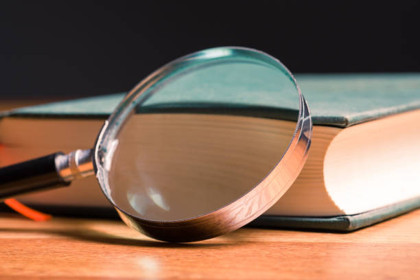Magnifying glass placed on the book stock photo