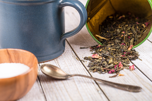 Green tea or herbal tea with cup, sugar and tea leafs