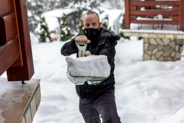 istock Man cleans sidewalk in winter. 1358760249