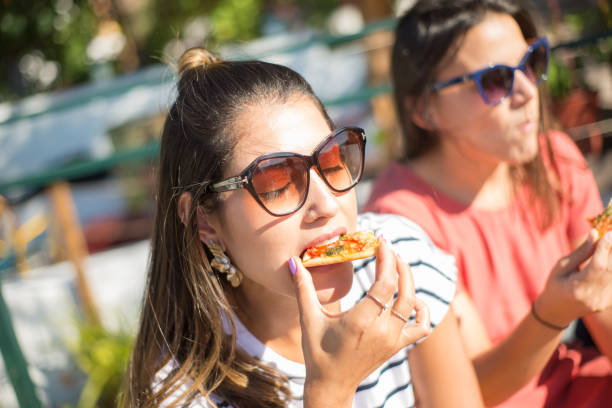 istock Young woman with closed eyes eating pizza 1358760288