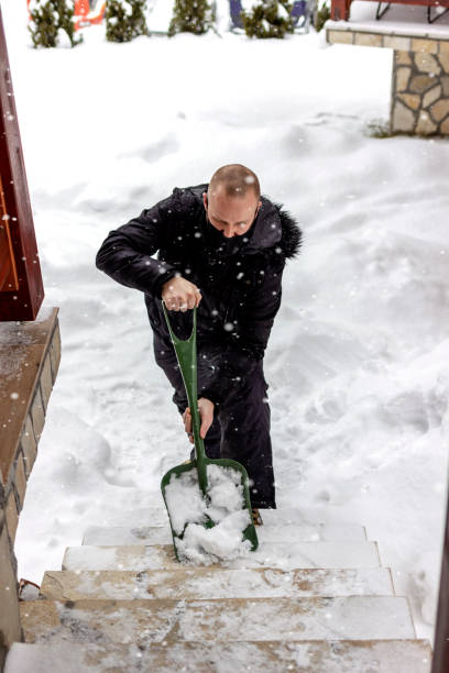 istock Man removing snow from sidewalk after heavy snowfall. 1358760293
