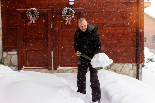 A man clean path near house from snow during strong blizzard.