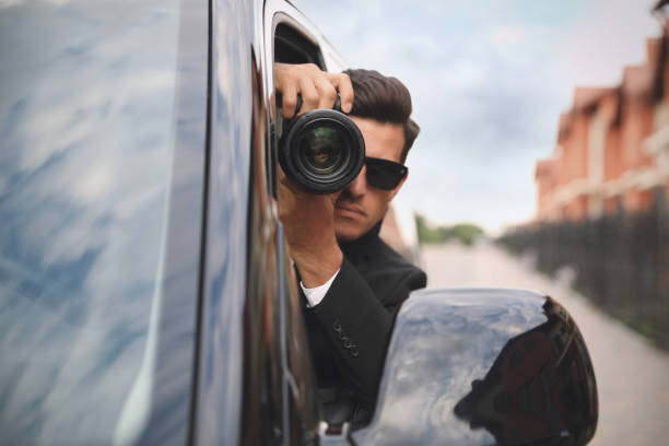 istock Private detective with camera spying from car 1358760536