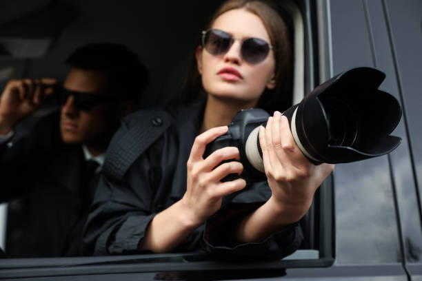 istock Private detectives with modern camera spying from car, focus on lens 1358760649