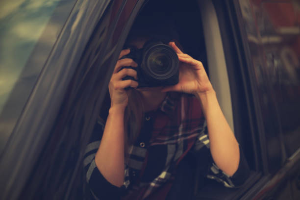 istock Private detective with camera spying from car 1358761175