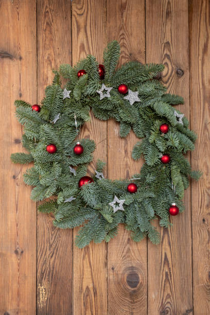 istock Green Christmas wreath made from fresh needles nobilis, Danish pine. Decorated with red Christmas balls and silver stars. Copy space 1358761484
