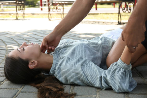 istock Man checking pulse of unconscious young woman outdoors. First aid 1358761862