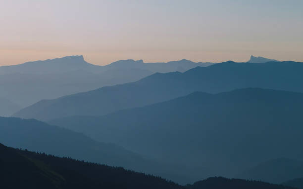 istock Mountain silhouettes layers in the sunset light 1358762321