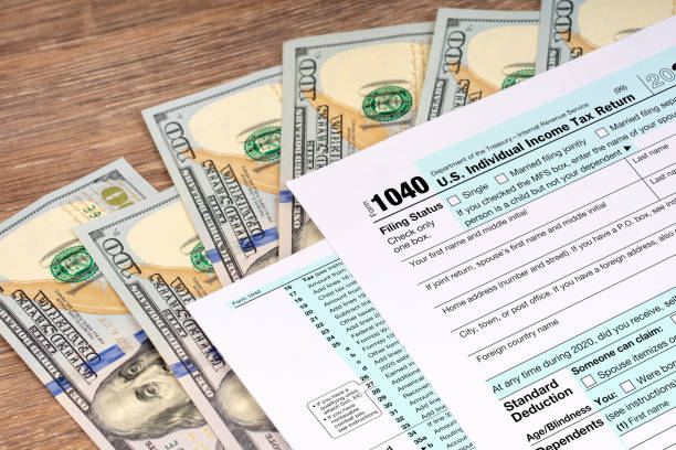달러 지폐와 세금 환급 신청서 - tax form tax form 1040 tax form 뉴스 사진 이미지