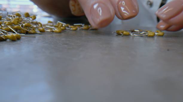 istock Heap of capacitors -  electronic components with human fingers 1358763394