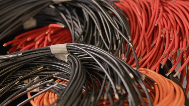 istock Heap of rolled up red and black cables side view 1358763451