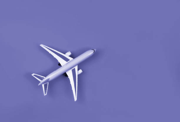 istock Airplane, miniature on very peri lavender background. 1358763514