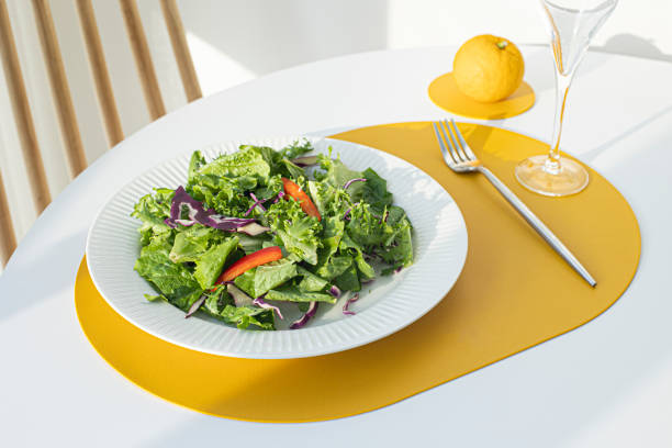istock Salad with yellow leather table mat on white table. 1358765347