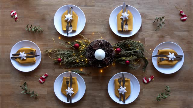 Flat lay animation: setting Christmas table with crockery, eating utensils and beautiful decorations for six diners. December, January