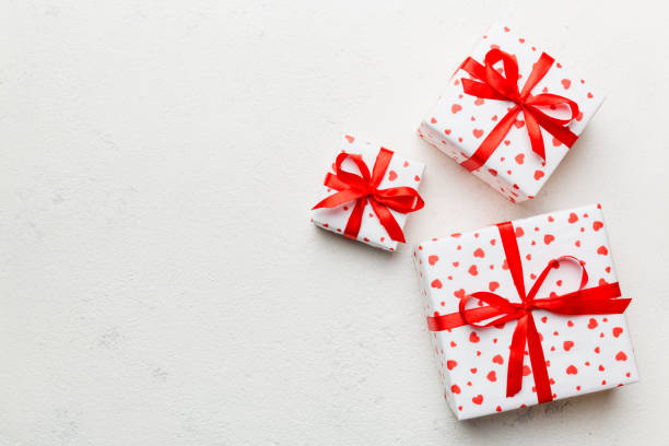 istock Valentine day composition: red gift box with bow and heart. Christmas present. View from above. Space for text. Holday greeting card 1358765435